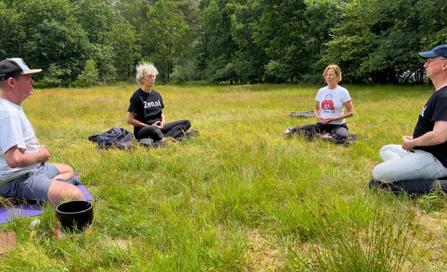 mensen mediteren in een cirkel op het gras op landgoed Den Treek in Lunteren